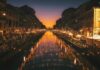 reflective photography of string lights above river